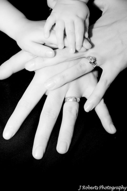 Family of 4 hands together for team work - family portrait photography sydney